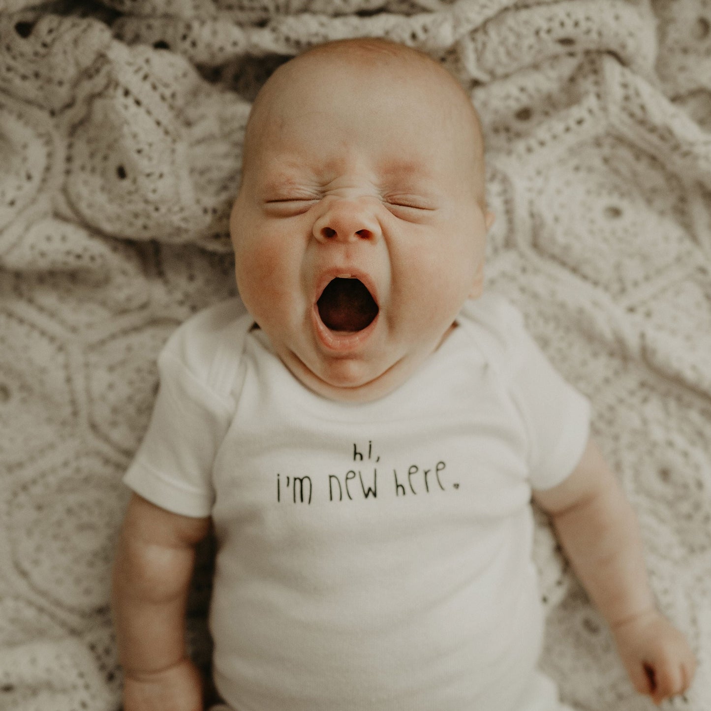 "Hi, I'm New Here" onesie